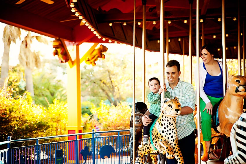 family of three with little boy riding carousel at the Houston Zoo