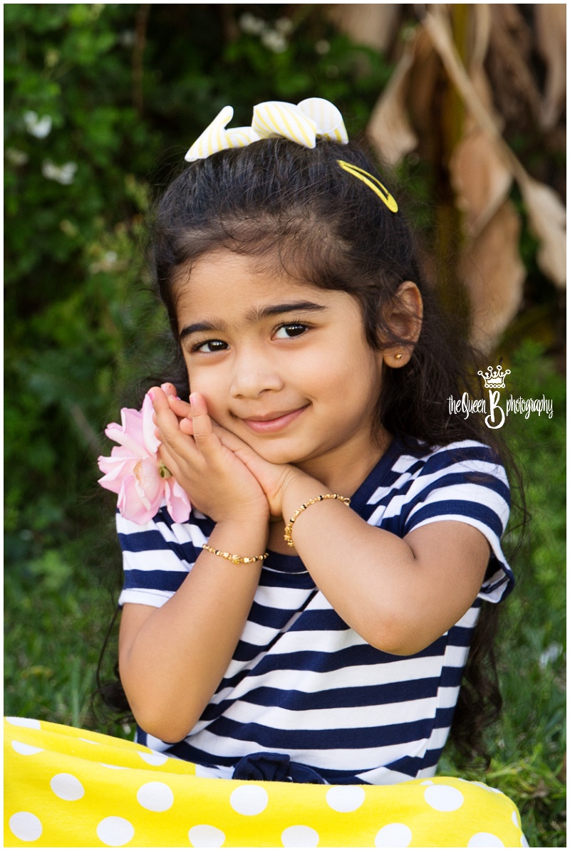 precious toddler girl with pink flower wearing navy and yellow dress