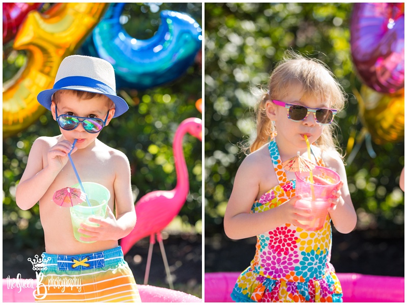 boy girl twins enjoying cool umbrella drinks and summer fun in sunglasses