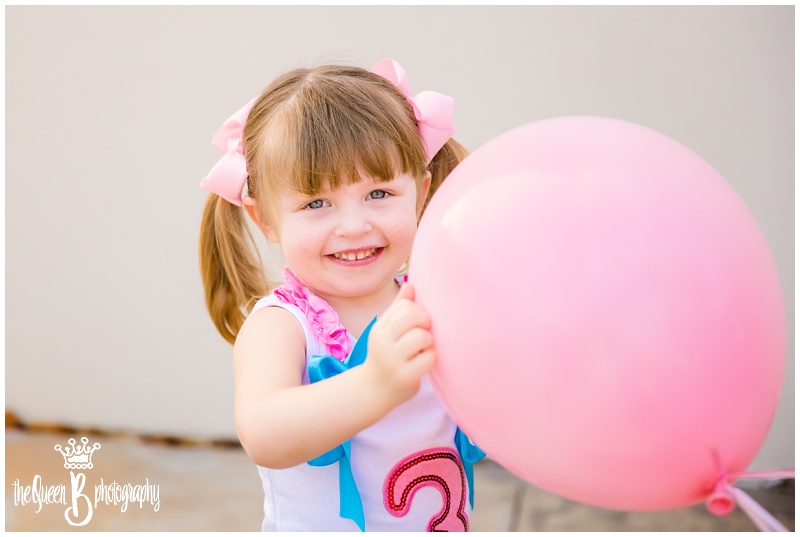 third birthday girl with pink balloon