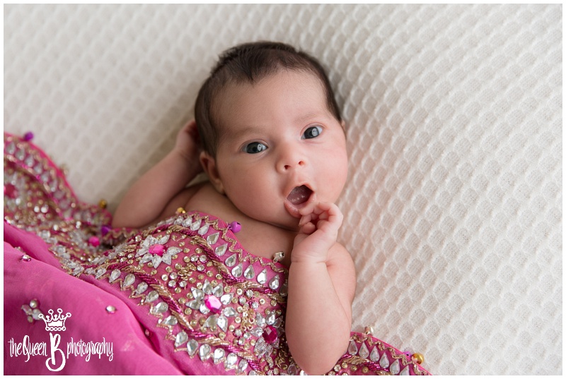 bright eyed newborn baby girl with pink beaded shawl