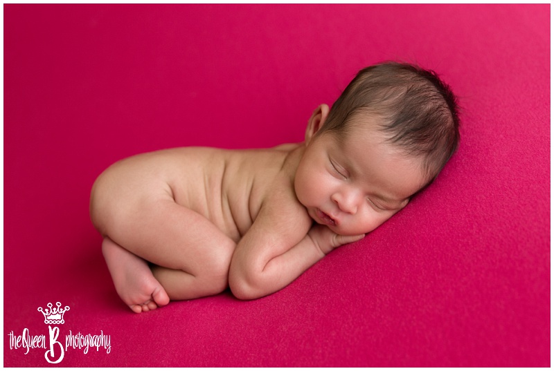 sleeping newborn baby girl on pink background