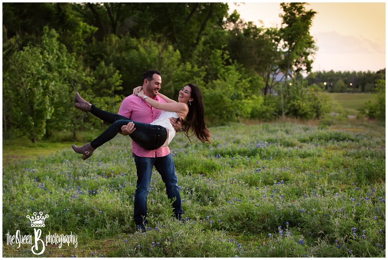 husband carrying wife in bluebonnets at sunset