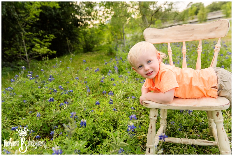 mischievous little boy in chair among texas bluebonnets