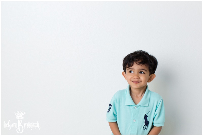 precious toddler boy in teal shirt in white studio portrait session