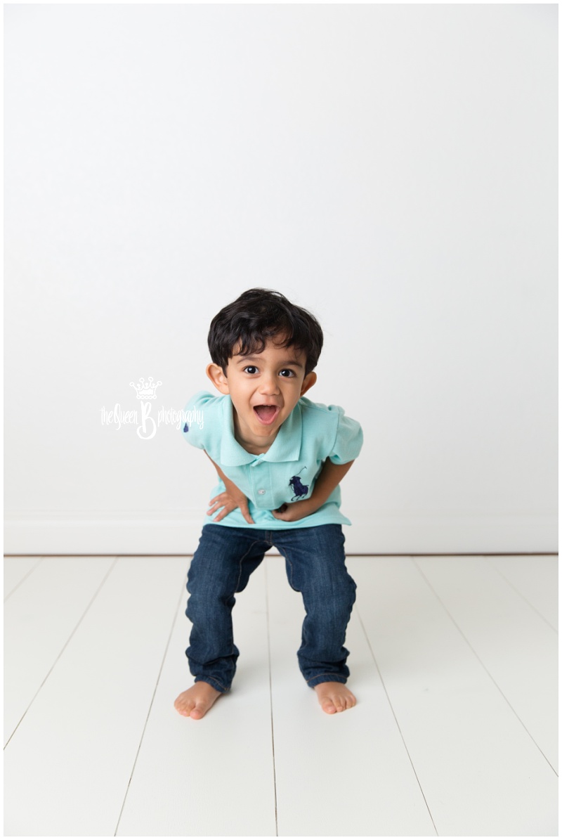 adorable toddler boy playing in white studio photo shoot