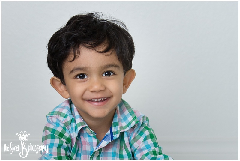 adorable smiling toddler boy in pastel plaid shirt