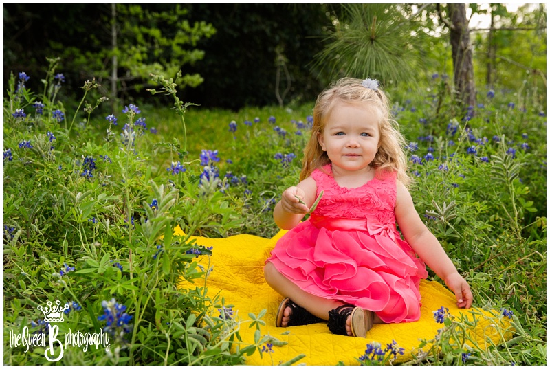 beautiful toddler girl sitting on yellow blanket in texas bluebonnets