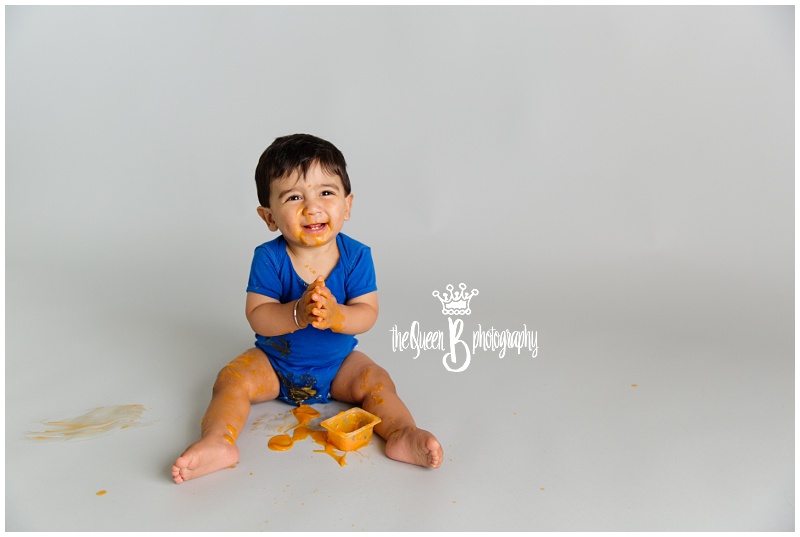 Unique 1st Birthday Photo Shoot boy playing with orange baby food