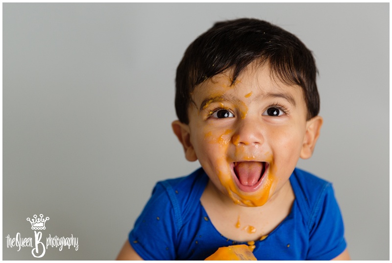 adorable 1 year old plays in orange baby food for 1st birthday portraits