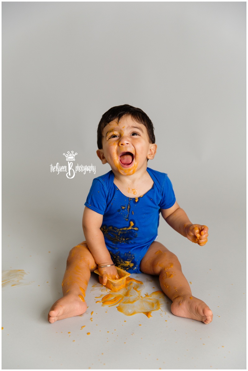 happy baby boy playing in baby food