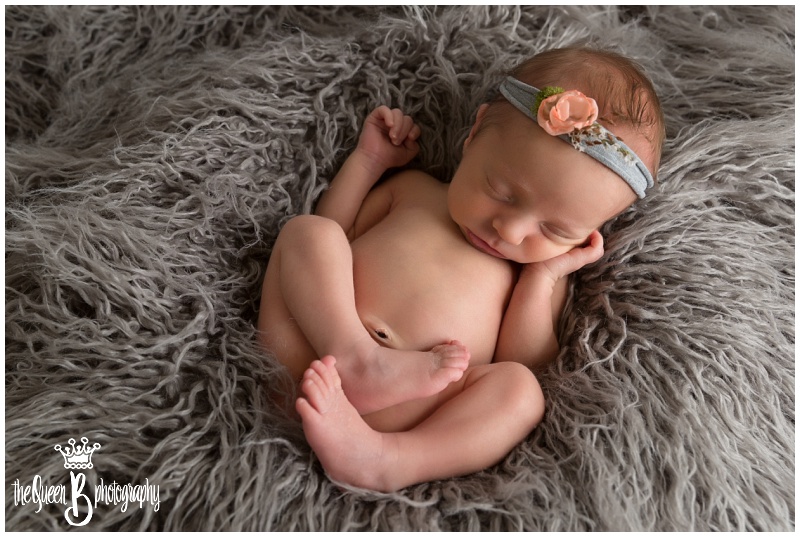 newborn baby girl sleeping in gray fur