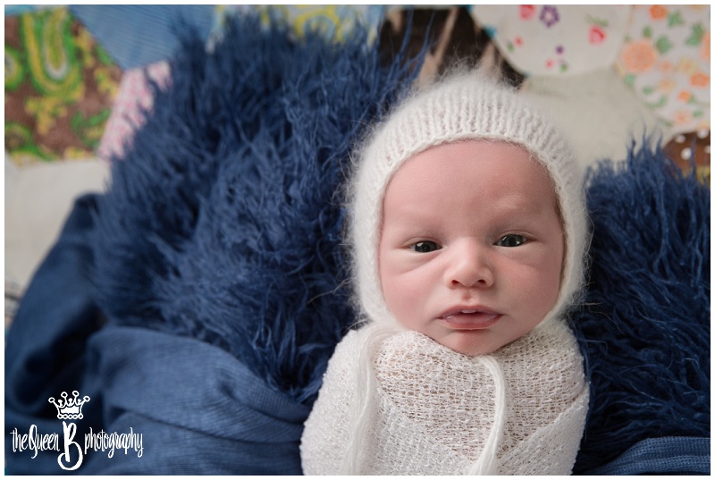 adorable awake newborn baby boy in white bonnet