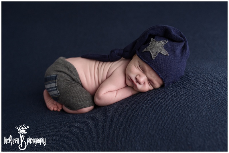 sleeping baby boy in shorts and slouchy hat on blue background