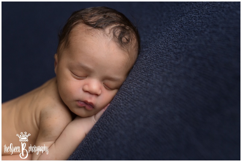 newborn boy sleeping soundly on blue background