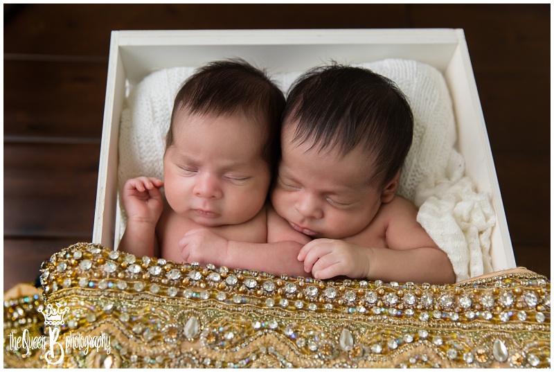 newborn twins in box with mother's gold beaded shawl 
