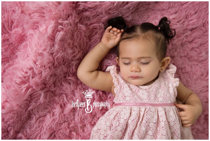 sleeping 9 month old baby girl on pink furry rug