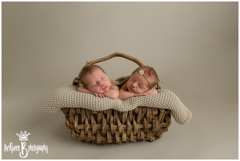 fraternal newborn twins sleeping in basket