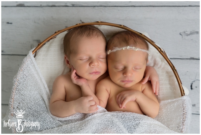boy and girl twin newborn babies snuggling in basket