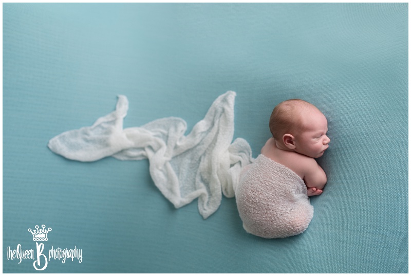 Houston Newborn Photographer The Queen B Photography captures sleeping baby boy on blue background