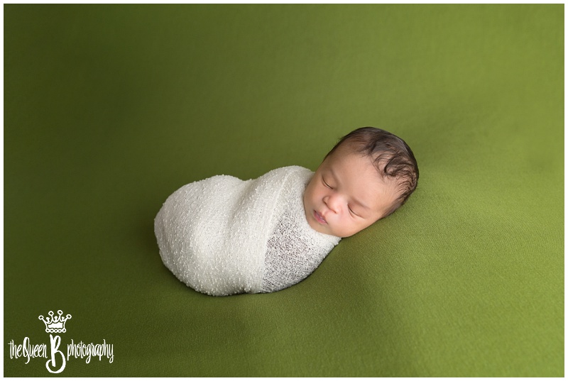 Sleeping newborn baby boy on green background